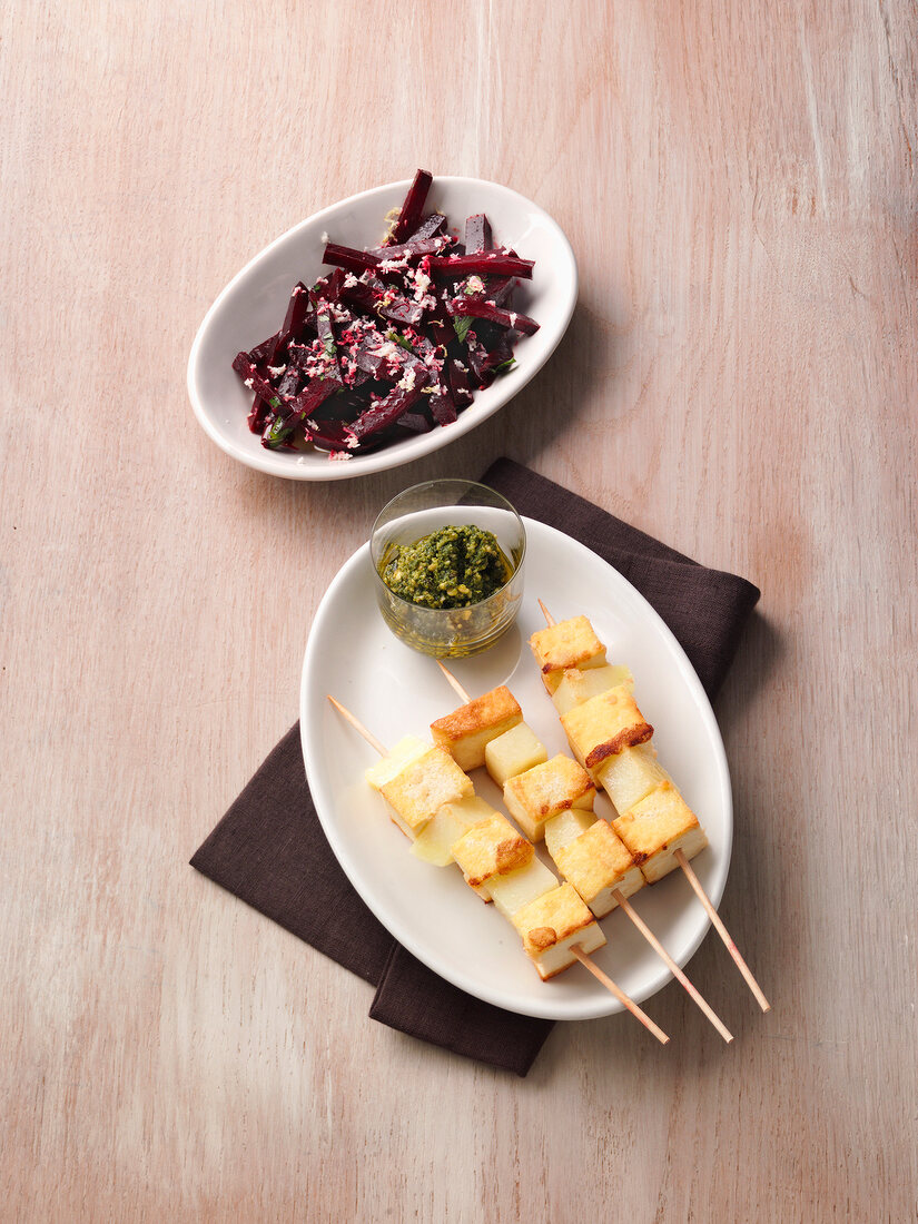 Beetroot and tofu skewers with arugula pesto, overhead view
