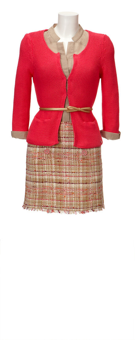 Skirt and red cardigan over silk blouse on mannequin against white background