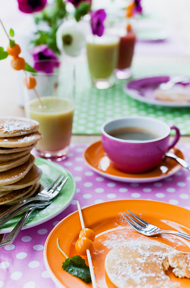 Coffee mug with coffee and pancakes on plate