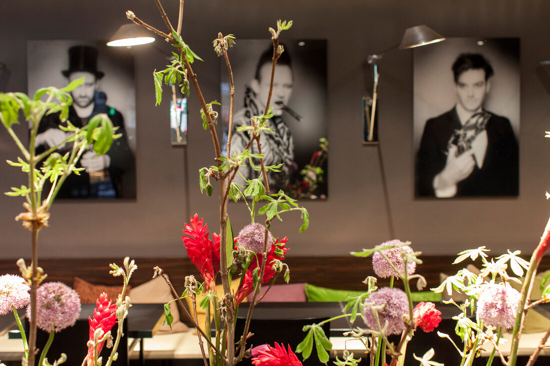 Photographs on wall with flowers in front at Restaurant Mani