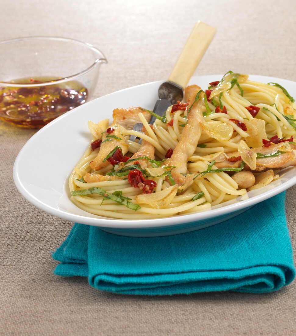 Pasta with garlic, olive oil and chicken on plate