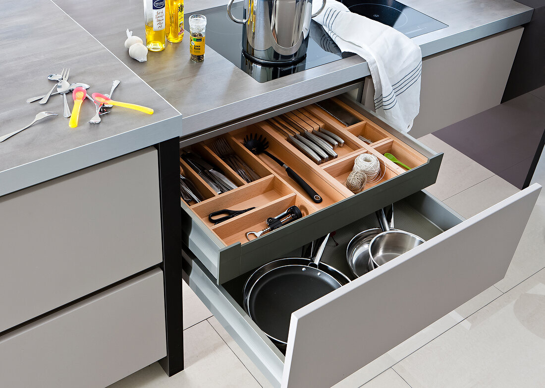 Close-up of open drawer with separator and kitchen utensils