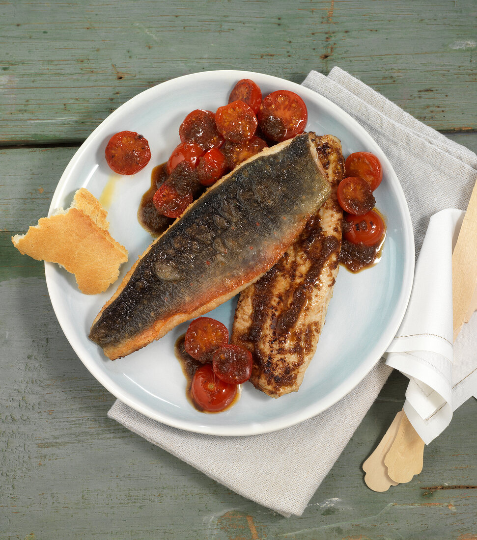 Fish fillets with ginger and tomatoes on plate