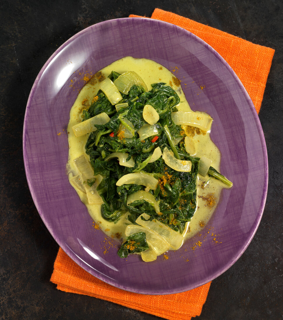 Onion and spinach in curry cream on plate