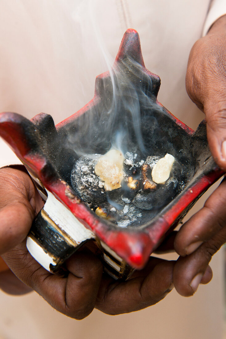 Close-up person holding incense burner at Salalah, Oman