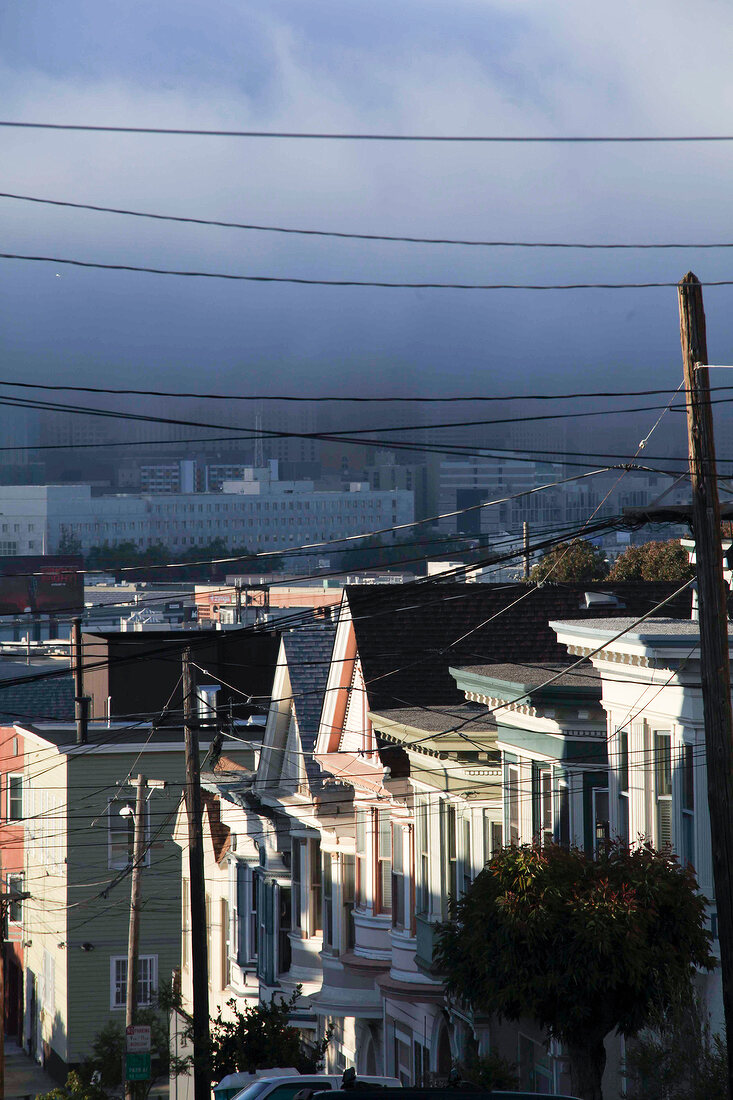 Power cables with houses and fog in San Francisco, California, USA