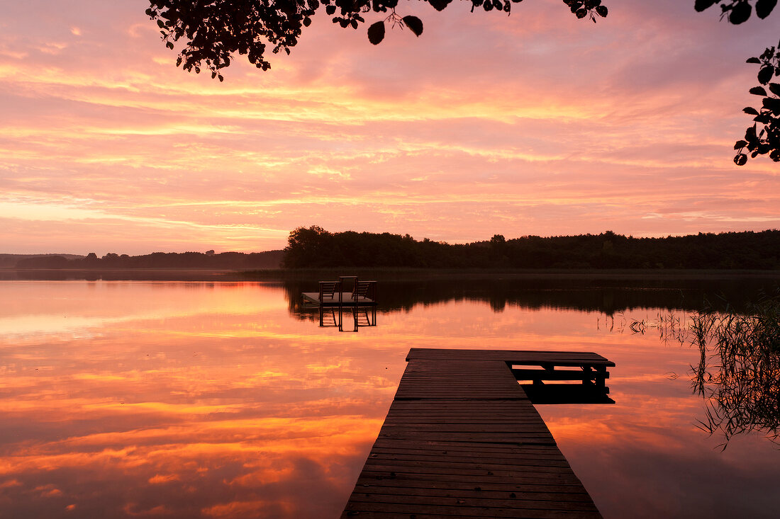 View of lake with jetty at dusk, Bradenburg, Germany