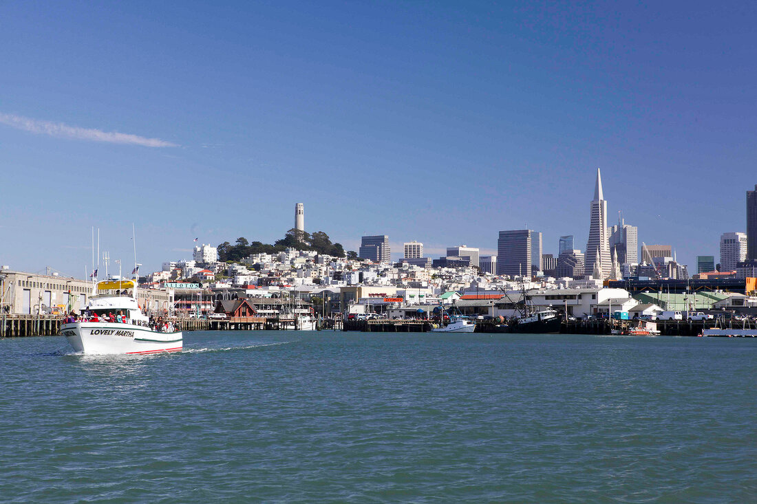 View of Fisherman's Wharf with cityscape and boat in San Francisco, California, USA
