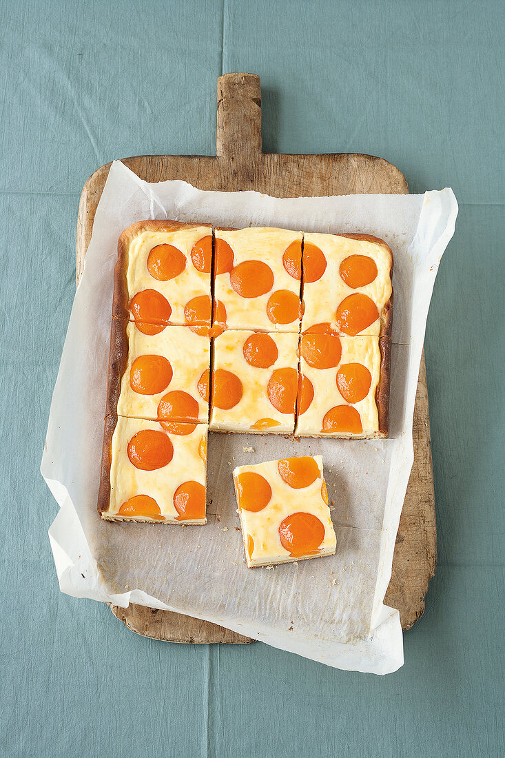 Sliced apricot cheese cake on chopping board