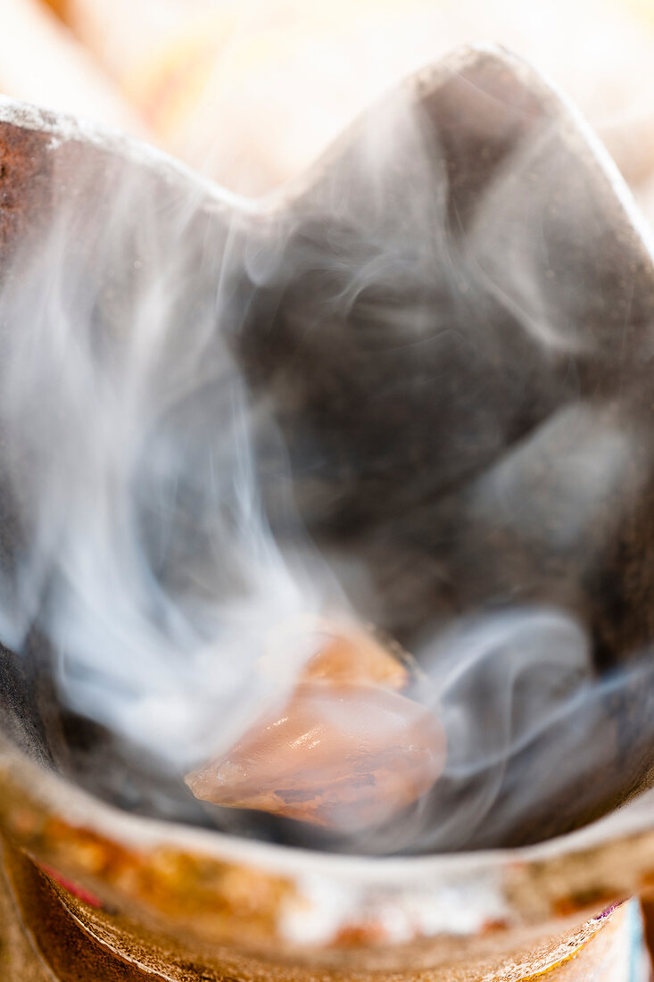 Close-up of burning incense in bowl with smoke in Salalah, Dhofar, Oman