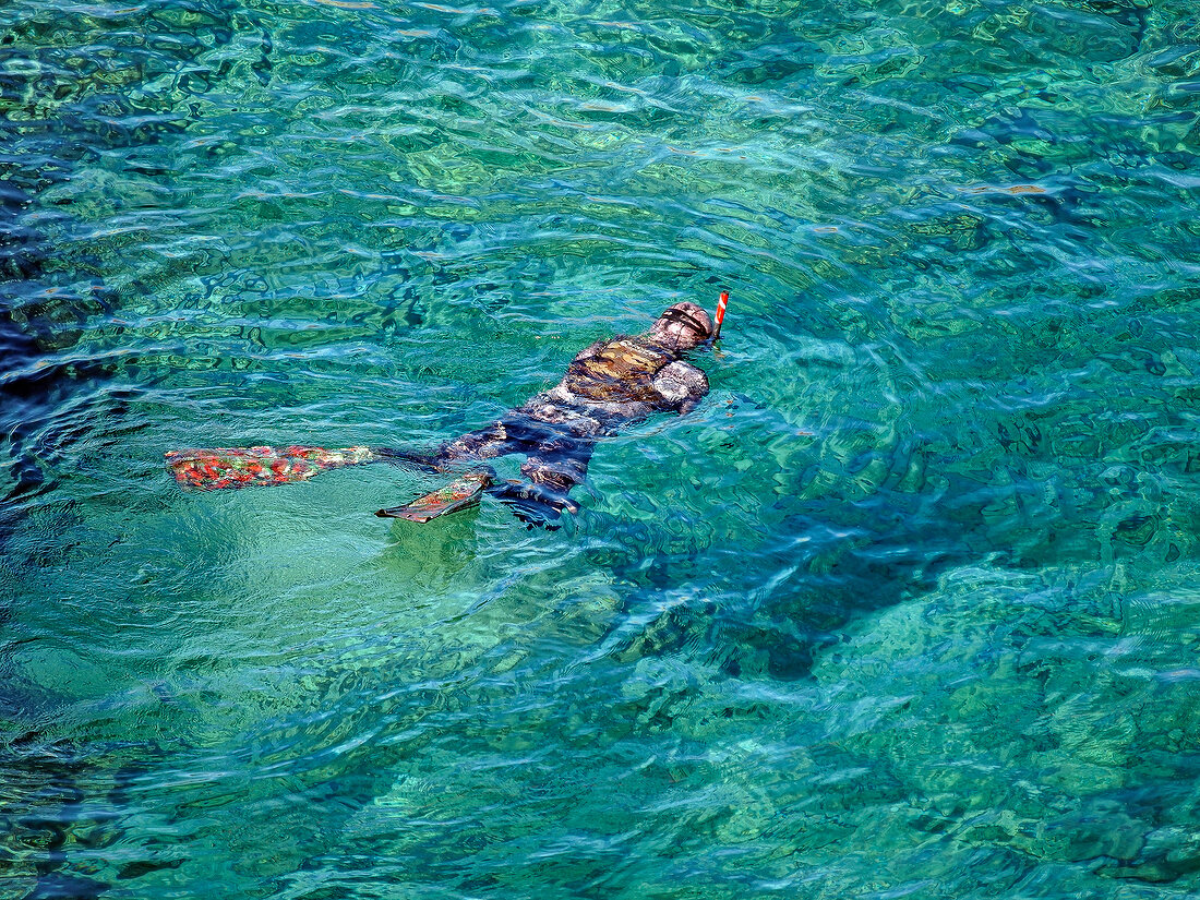 Person swimming in sea near Costa Paradiso in Sardinia, Italy