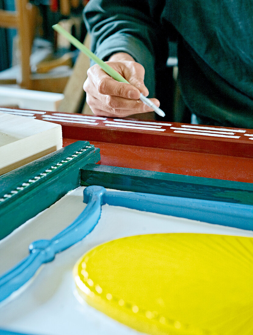 Man painting door with paintbrush in traditional style