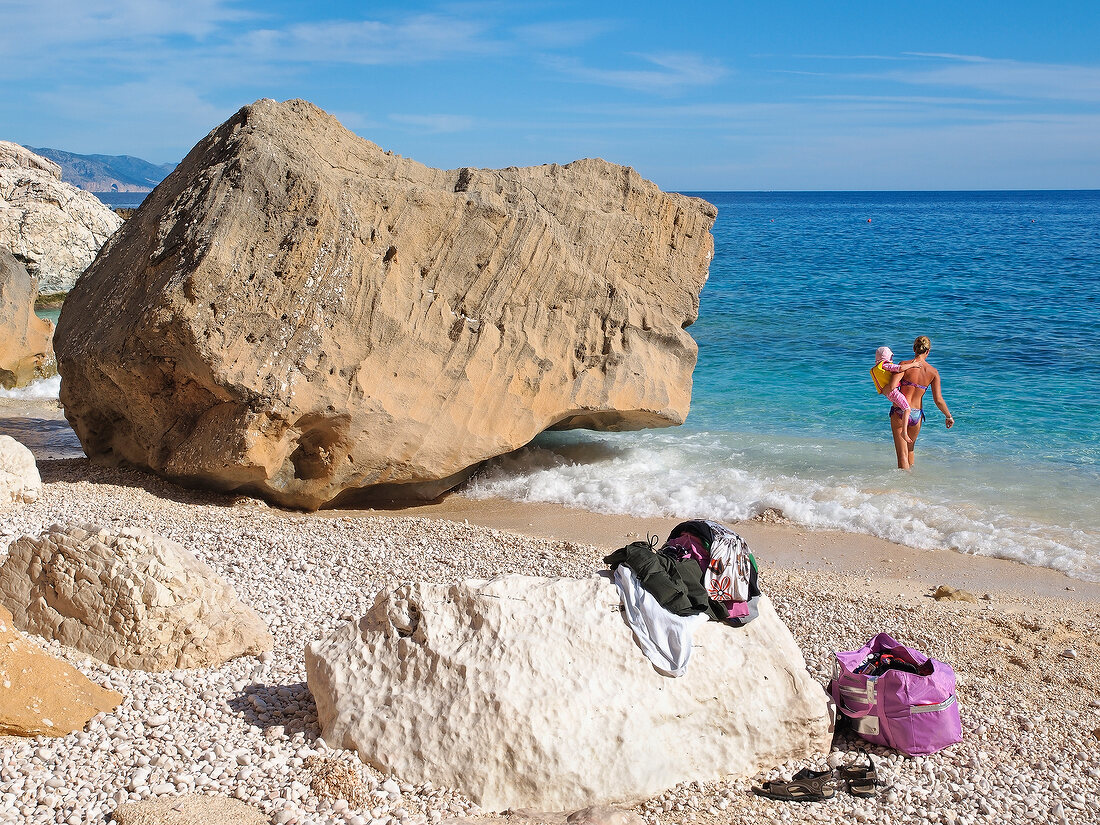 View of woman with child at Cala Mariolu, gulf of orosei, Sardinia, Italy