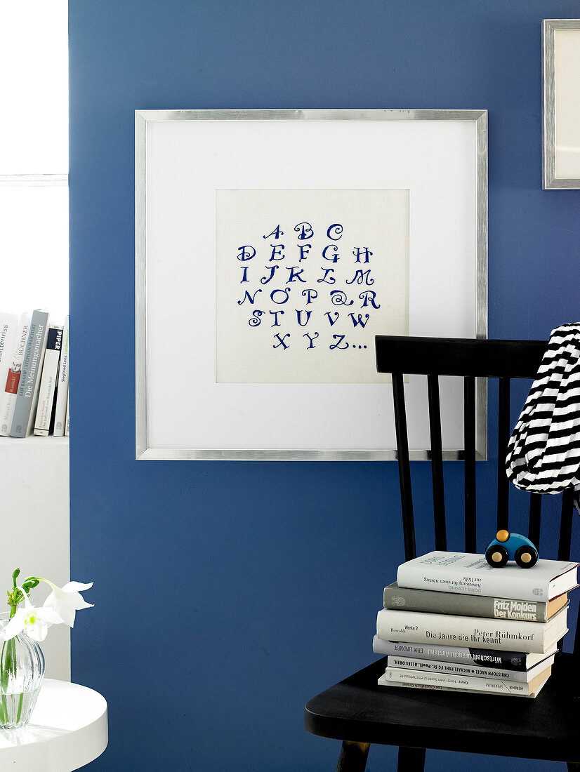 Alphabets embroidered on photo frame against blue background