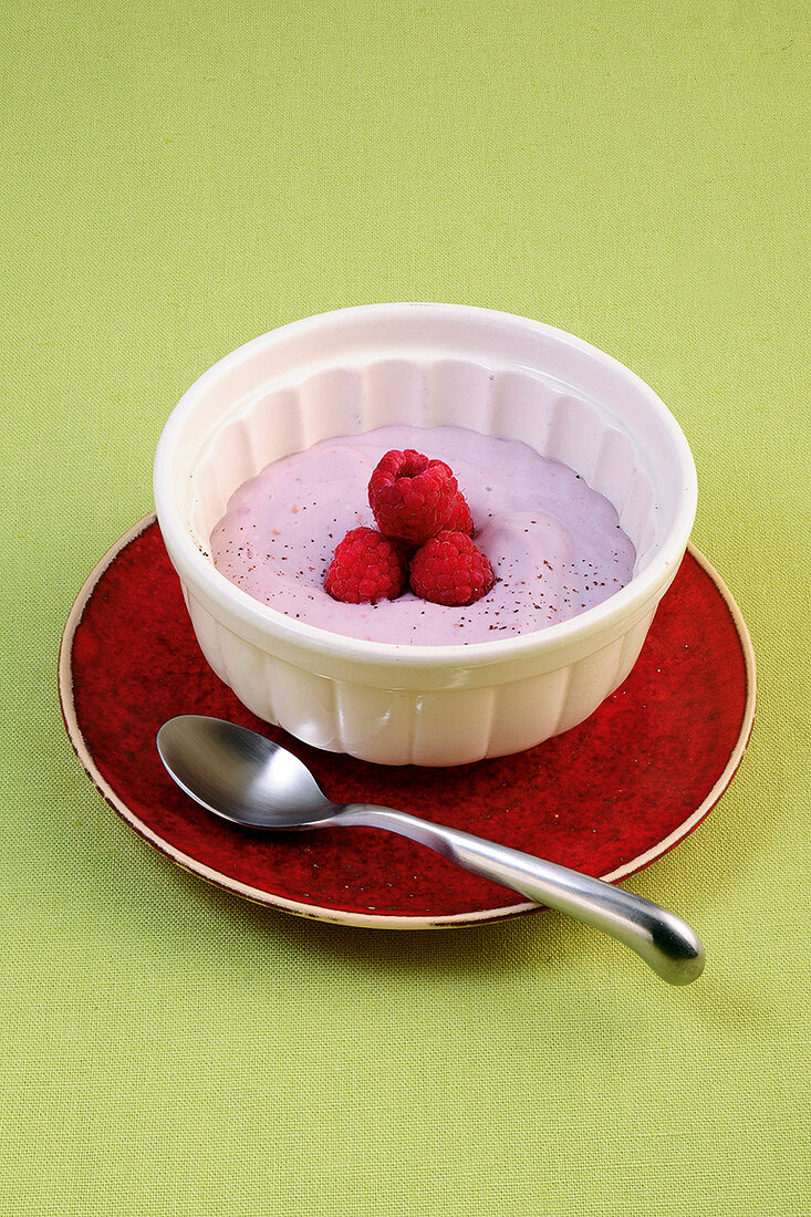 Raspberry pudding and tofu garnished with raspberries on plate