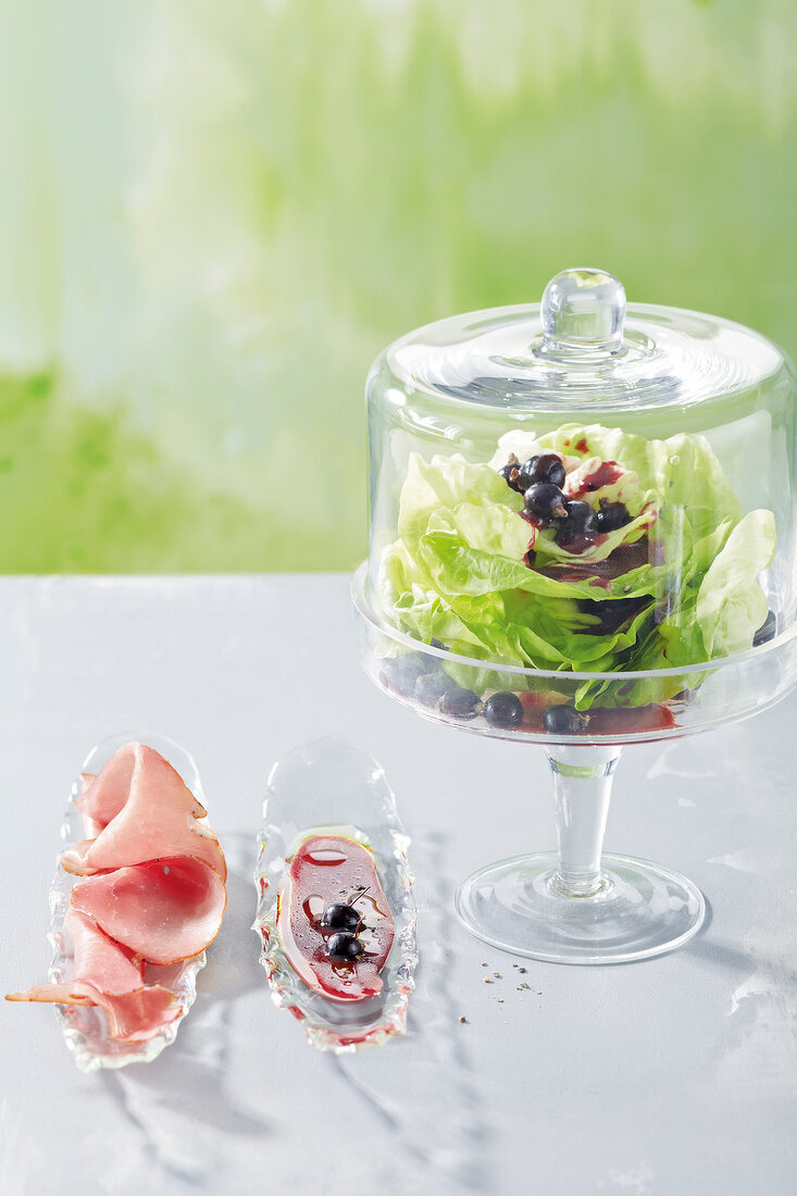 Lettuce with black currant and berry vinaigrette on glass tray