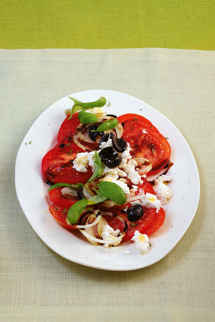 Tomato salad with feta cheese and herb on plate