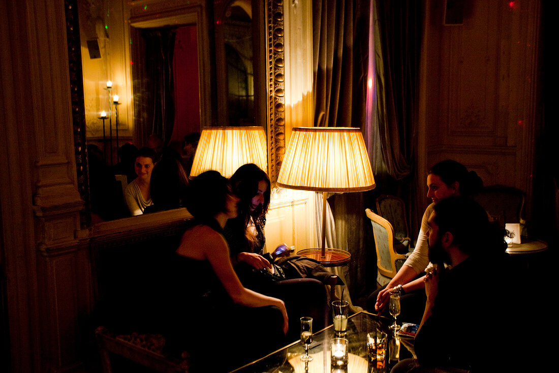 Women relaxing in Le Carmen at night in Paris, France