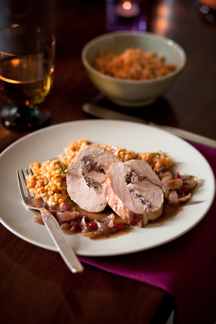 Rolled turkey roast with pesto filling and red lentils on plate