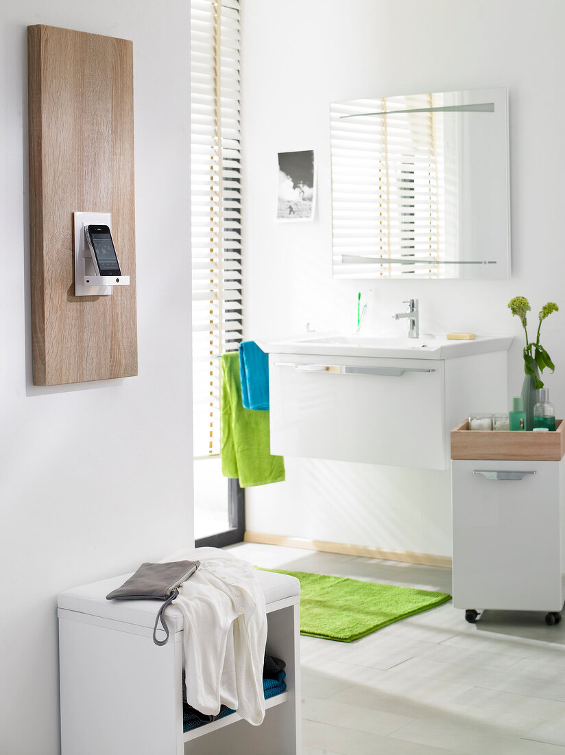 Phone on dock speaker on wooden panel in bathroom