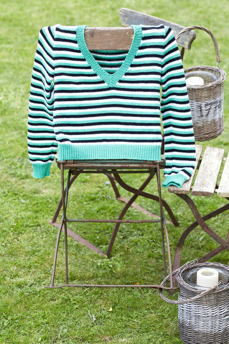 Streifen-Pulli, hängt auf dem Stuhl, im Garten