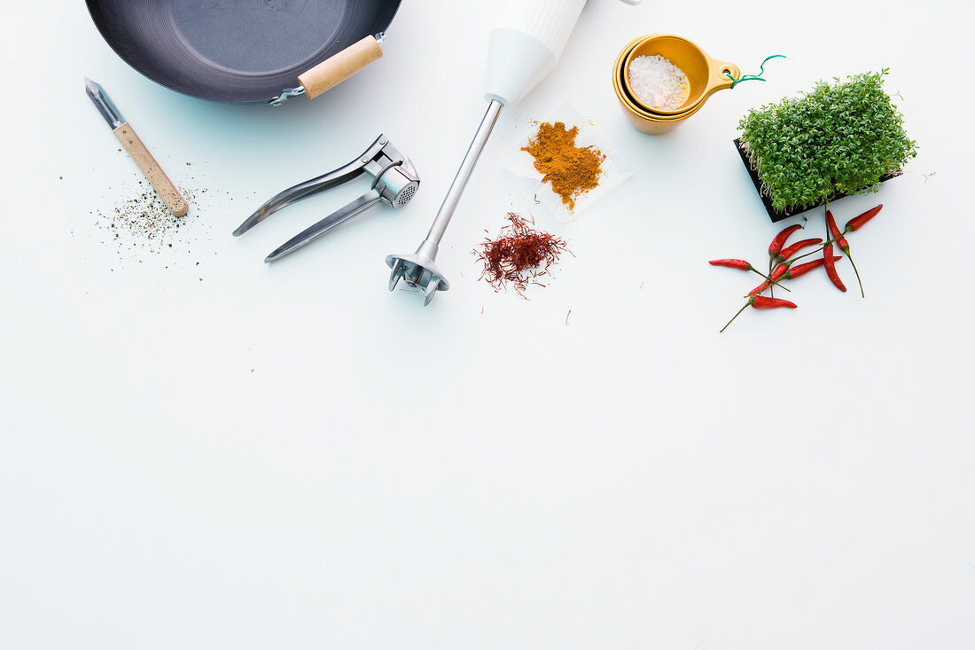 Different kitchen utensils and spices on white background