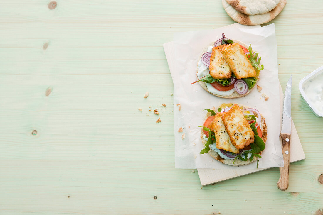 Pita bread with vegetable salad on paper, copy space