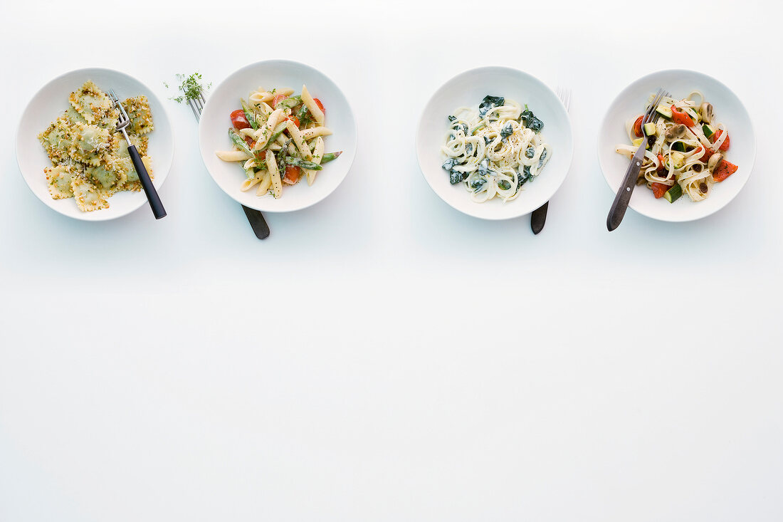 Four different types of pasta in bowls