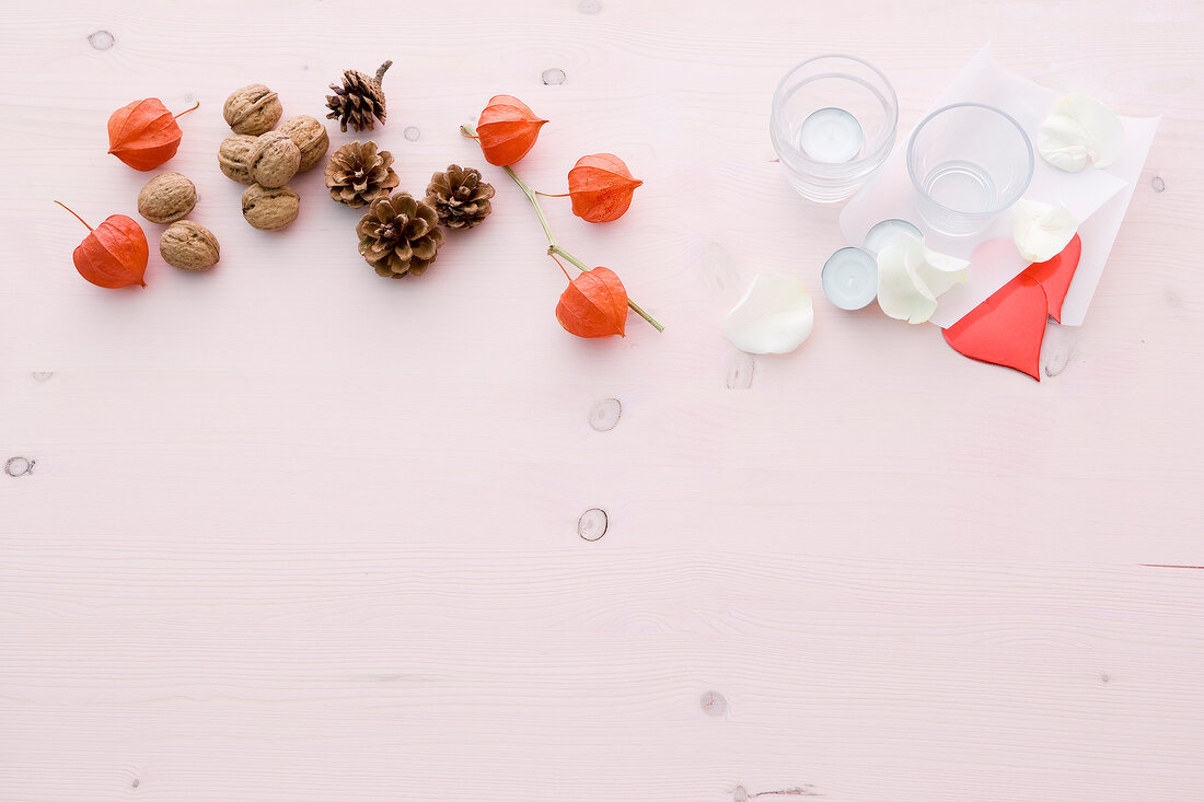 Walnuts and autumnal decorations on pink background, overhead view