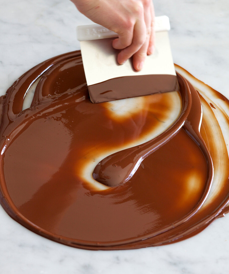 Close-up of hand tempering melted chocolate