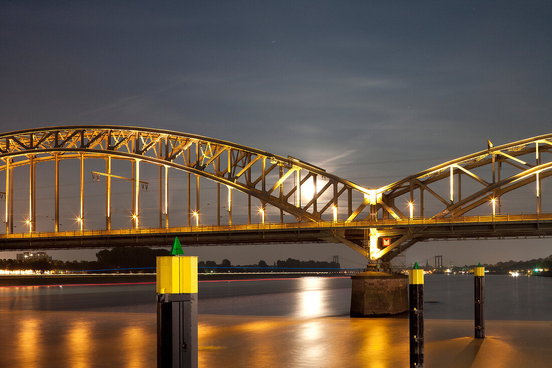 Illuminated Hohenzollern bridge over river Rhine at night, Cologne, Germany