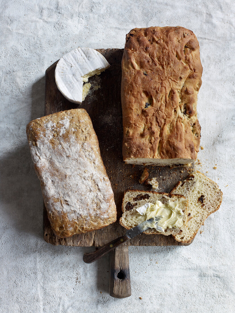 Brot, Apfelbrot links, Käse, Backpflaumenbrot rechts, Holzbrett