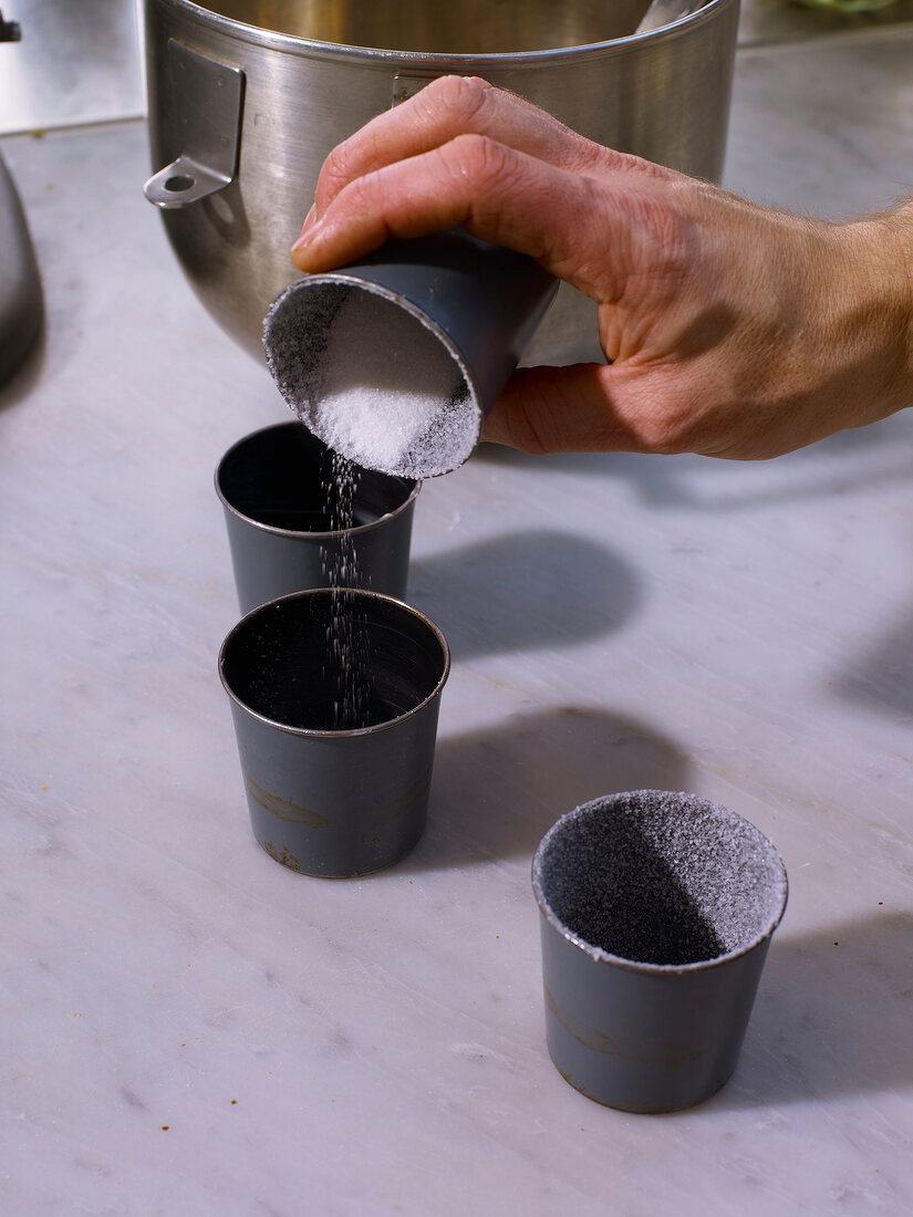 Three casserole cup with sugar being poured in cup