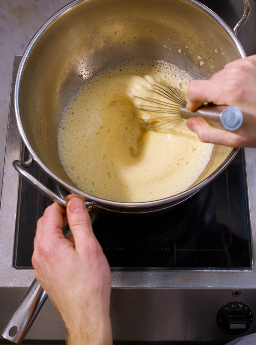 Eggs being whisked in frying steel pan