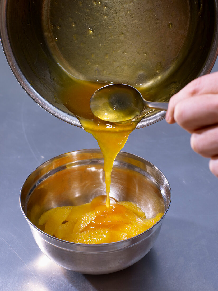 Adding juice to orange slices for passion fruit cream with orange salad