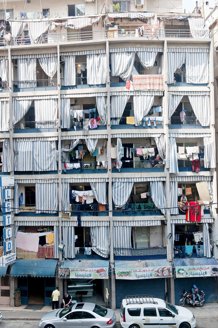 Facade of building with balconies and striped curtains