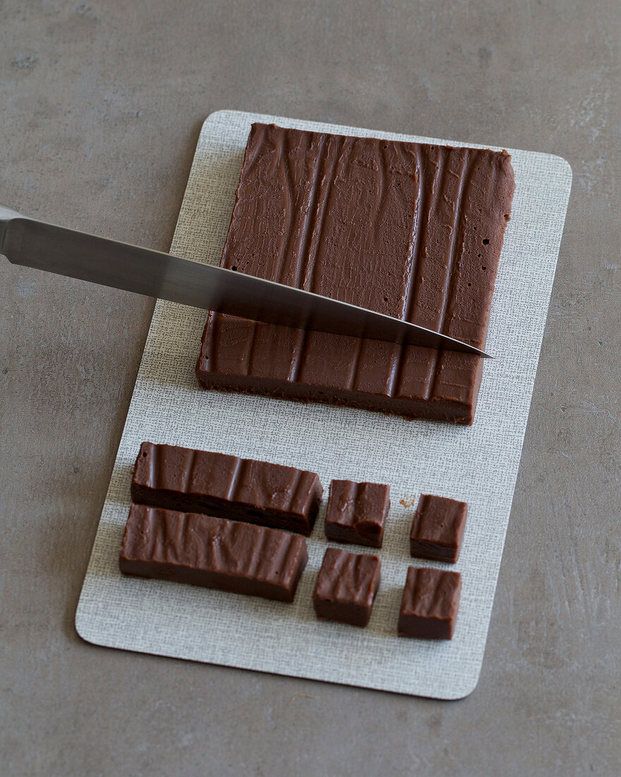 Slab of chocolate being cut into pieces, step 3