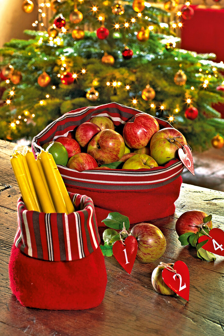 Tischkörbe aus Stoff gefüllt mit Äpfeln und Kerzen