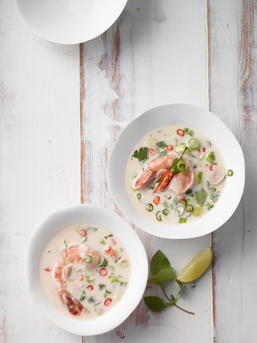 zwei Teller mit Thai-Kokossuppe, Garnelen und Zitronengras