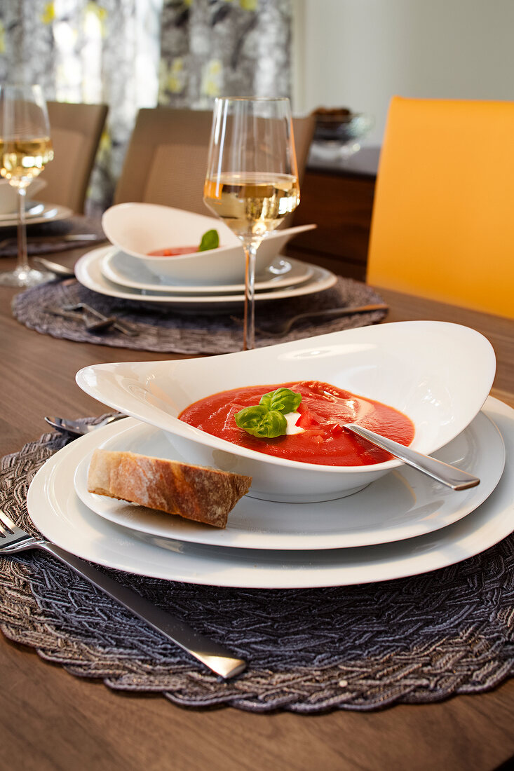 Close-up of tomato soup in bowl with slice of bread