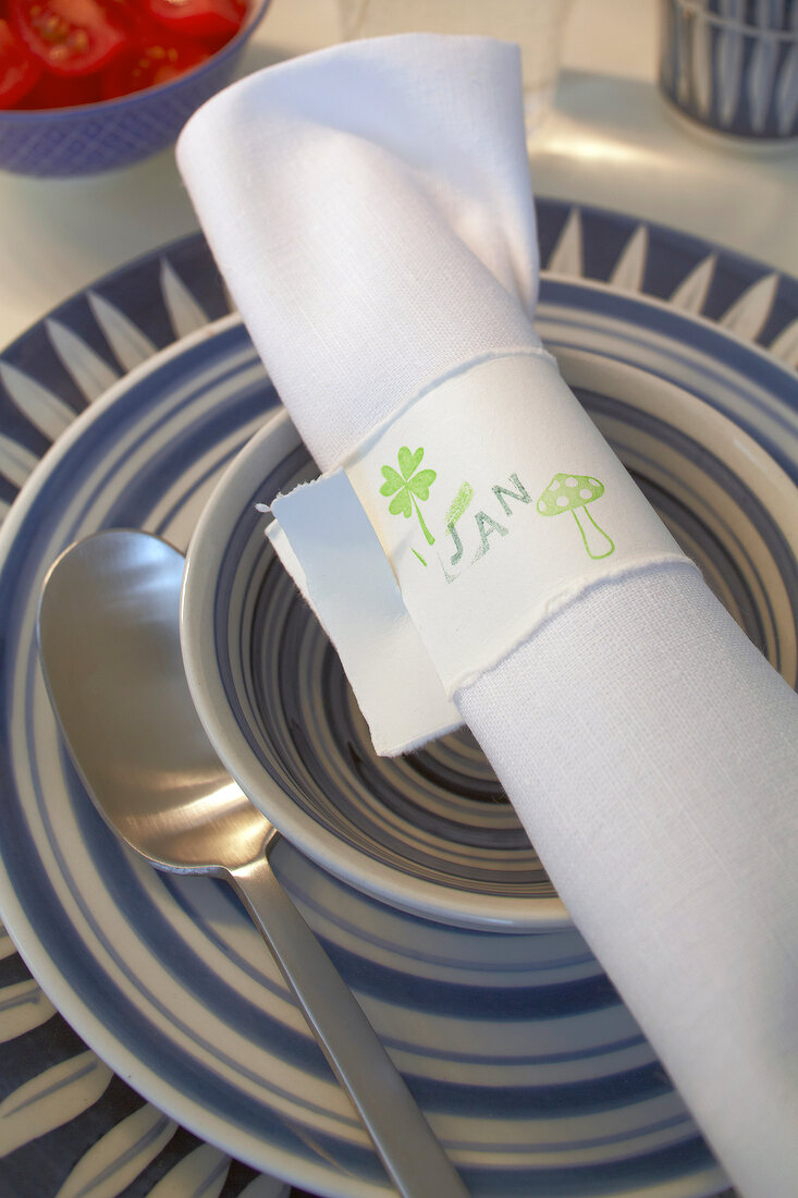 Rolled napkin in napkin ring with name 'Jen'