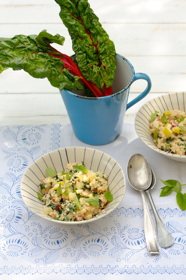 Vase of mangold leaves and millet salad in bowl