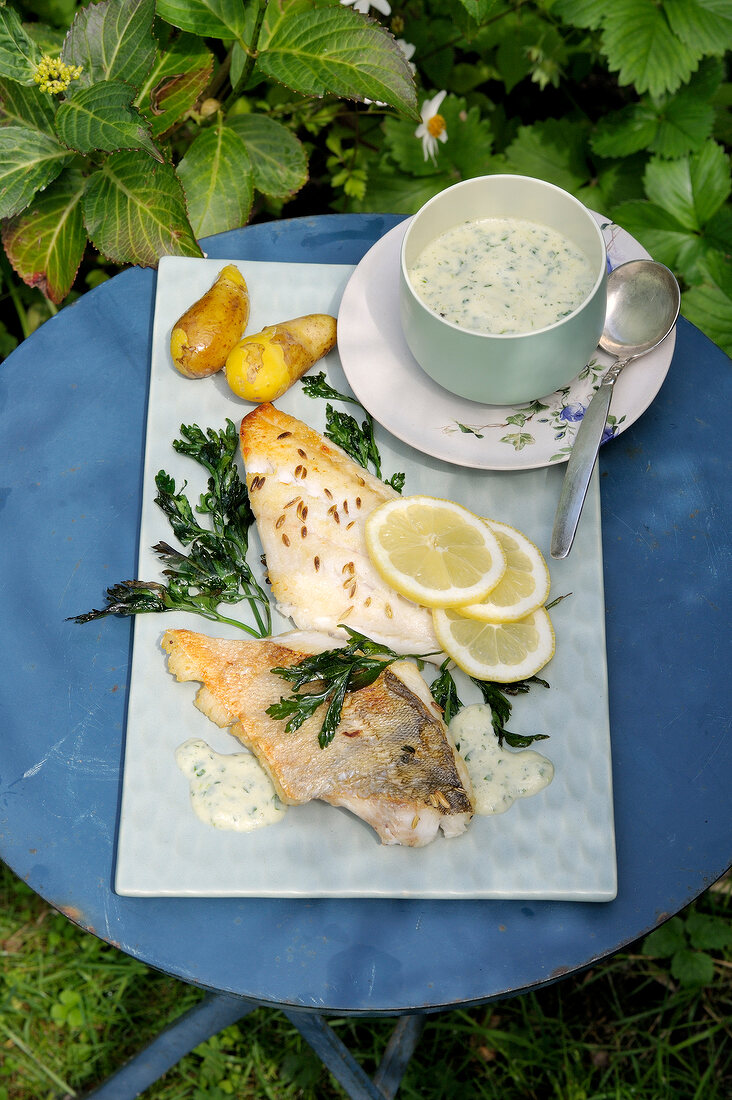 Fennel fish with lemon wedges and dip