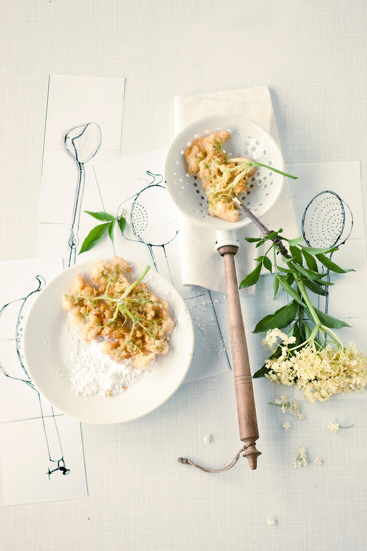 Elderflower fritters on plate with frying spoon
