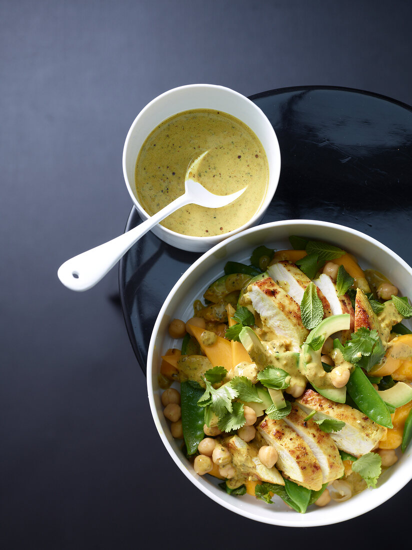 Bowl of chicken and avocado salad with mango, overhead view