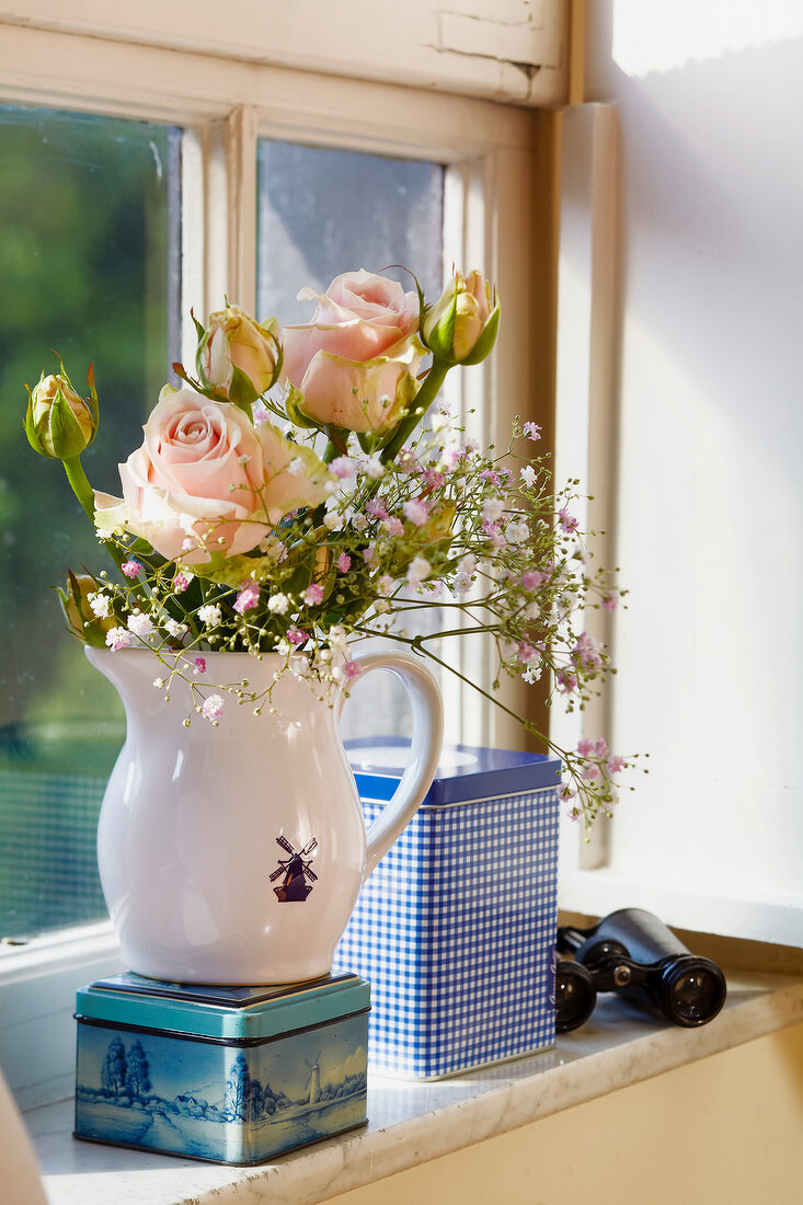 Milchkrug als Vase, Keksdosen, Rosen , Blumen auf dem Fensterbrett