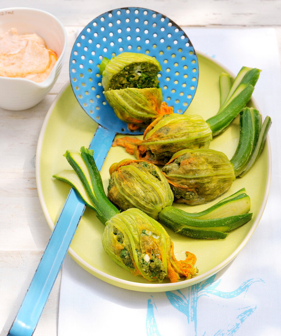 Stuffed zucchini flowers on oval plate