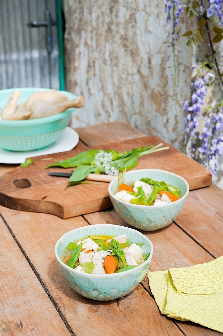 Clear chicken soup with vegetables and wild garlic