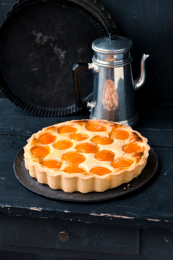 Apricot tart on plate with stainless steel thermos
