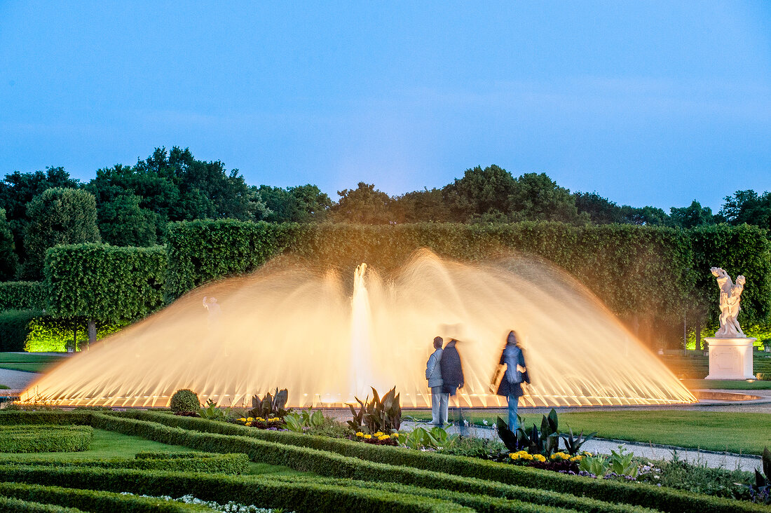 Woman in front of fountains at Royal Gardens in Herrenhausen Palace, Hannover, Germany